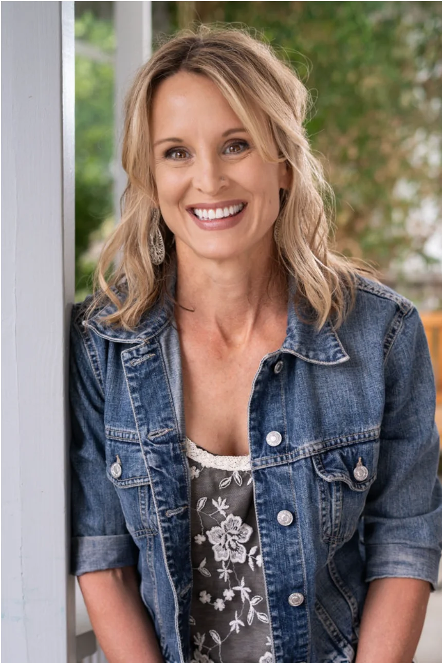 Tania Henderson, MA, LPC, smiling in a denim jacket on a sunlit porch